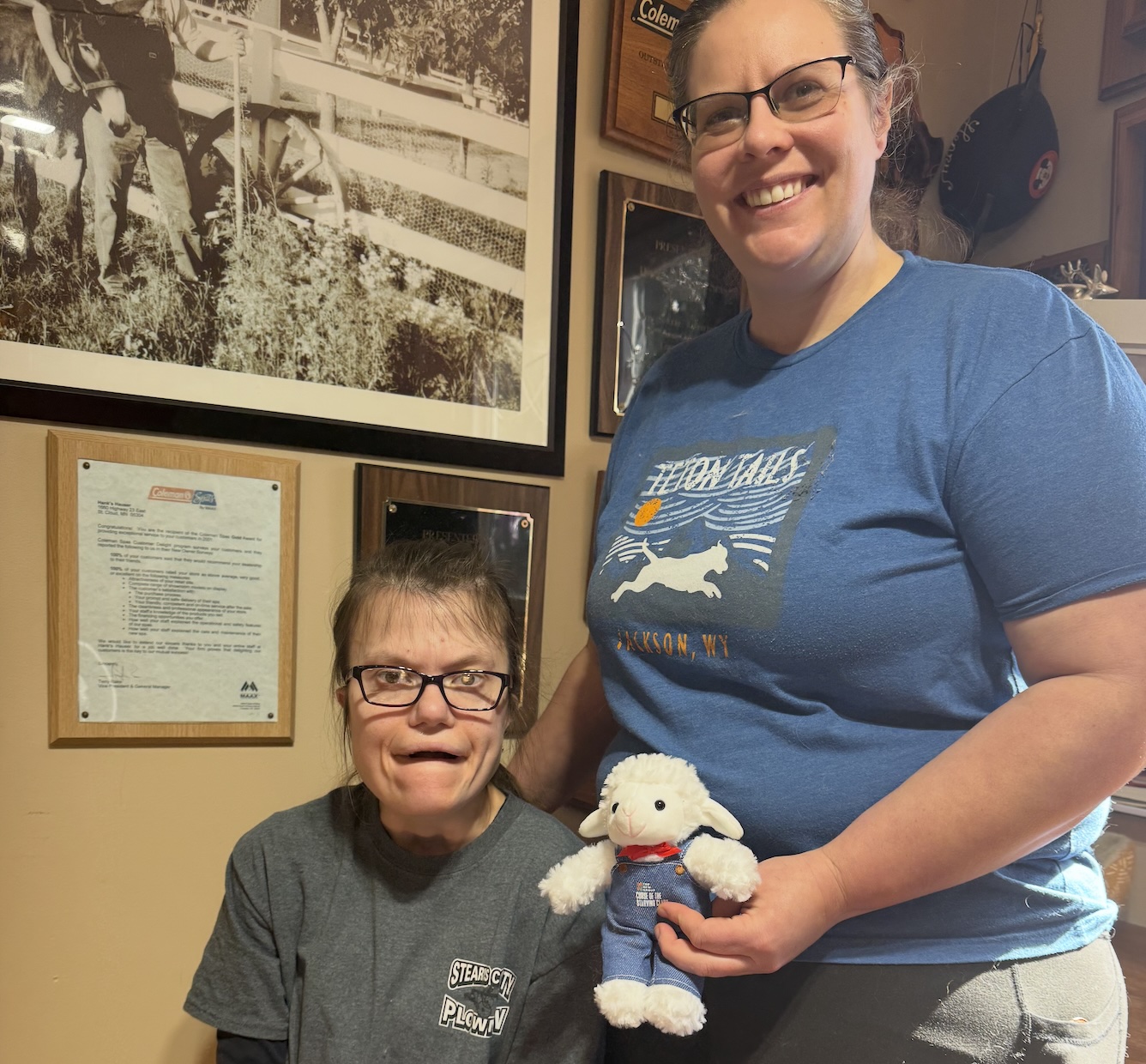Lis and her sister Emily smiling together with a stuffed sheep